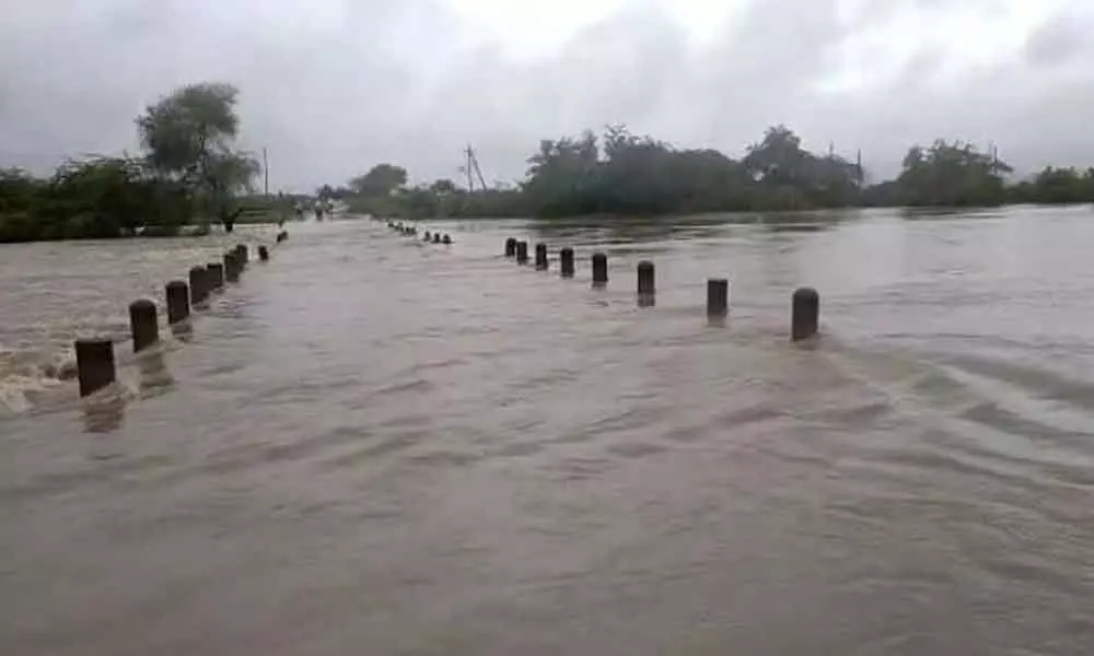 Konkeruvagu floodwater overflowing on to the Chinakancherla- Pichikalapalem road in Guntur district on Saturday