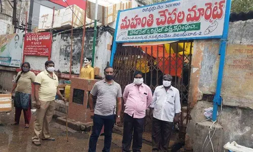 Officials enforcing closure of Mahanti fish market in Besant Road in Vijayawada on Sunday