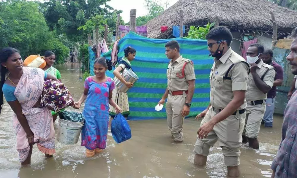 Women moving to a safer place from the flood-hit Pallepalem village in Repalle mandal in Guntur district on Monday