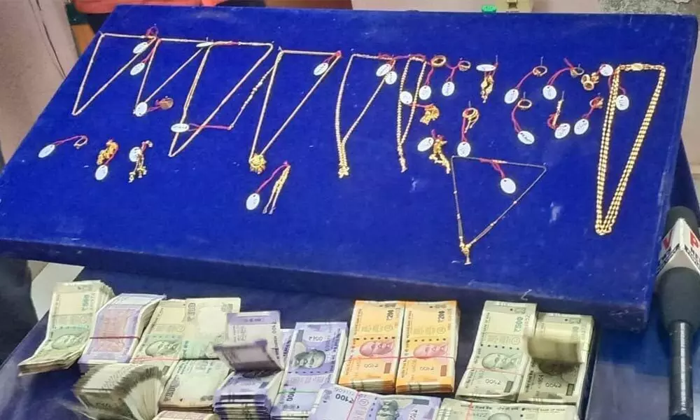 Cops displaying the recovered jewellery and cash from the accused
