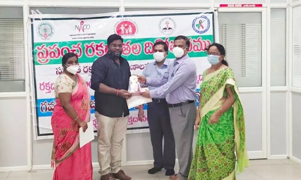 GGH RMO Venugopal Reddy and medical officer of blood bank Suneetha felicitating Sandeep from Magunta Charitable Trust in Ongole on Thursday