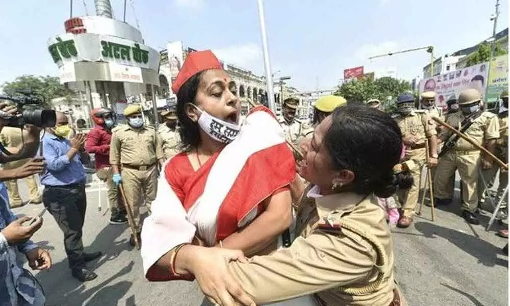 Police personnel detain Samajwadi Party activists during a protest against the death of a 19-year-old Dalit woman in Hathras, in Lucknow.