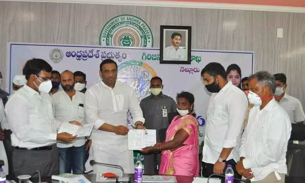 Ministers M Goutham Reddy and P Anil Kumar Yadav distributing ROFR pattas to a beneficiary in Nellore on Friday. Collector K V N Chakradhar Babu is also seen.
