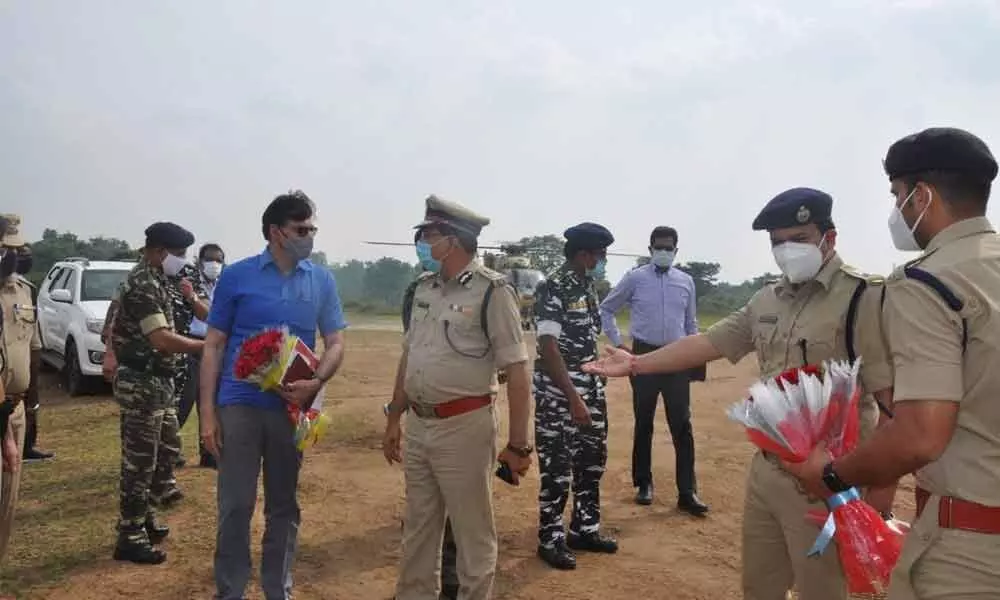 Senior Security Advisor to the Union Home Ministry K Vijay Kumar (blue shirt), and Telangana DGP M Mahender Reddy at the helipad in Venkatapuram of Mulugu district on Sunday