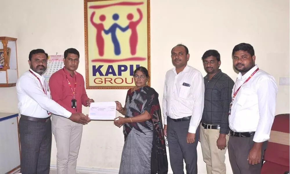 Kapil Chits Company Yadadri Regional Manager B Yadagiri handing over a cheque for Rs 8 lakh to Meda Sujatha Keshava Reddy at the office in Nalgonda on Monday