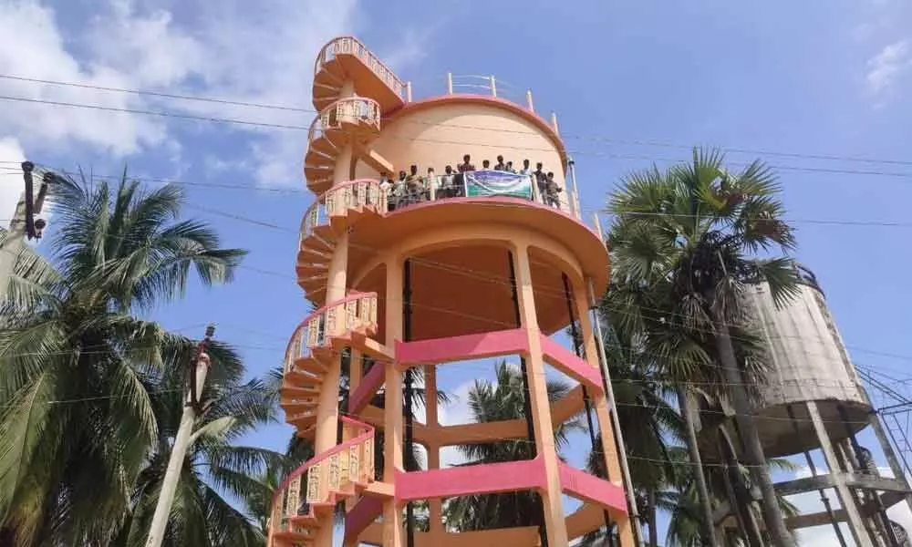 Village volunteers stage a protest from atop a water tank  at Jaggampeta in  Kirlampudi Mandal on Tuesday