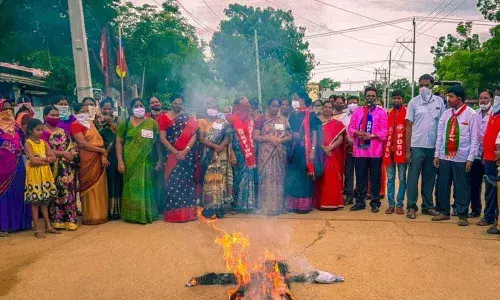 Members of women organisations burning effigy of State and Central governments at a main centre in Khammam on Sunday