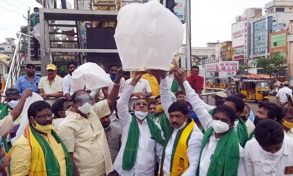 TDP MLA Gorantla Buchaiah Chowdary releasing light balloons into air at Kotipalli bus station in Rajamahendravaram on Monday