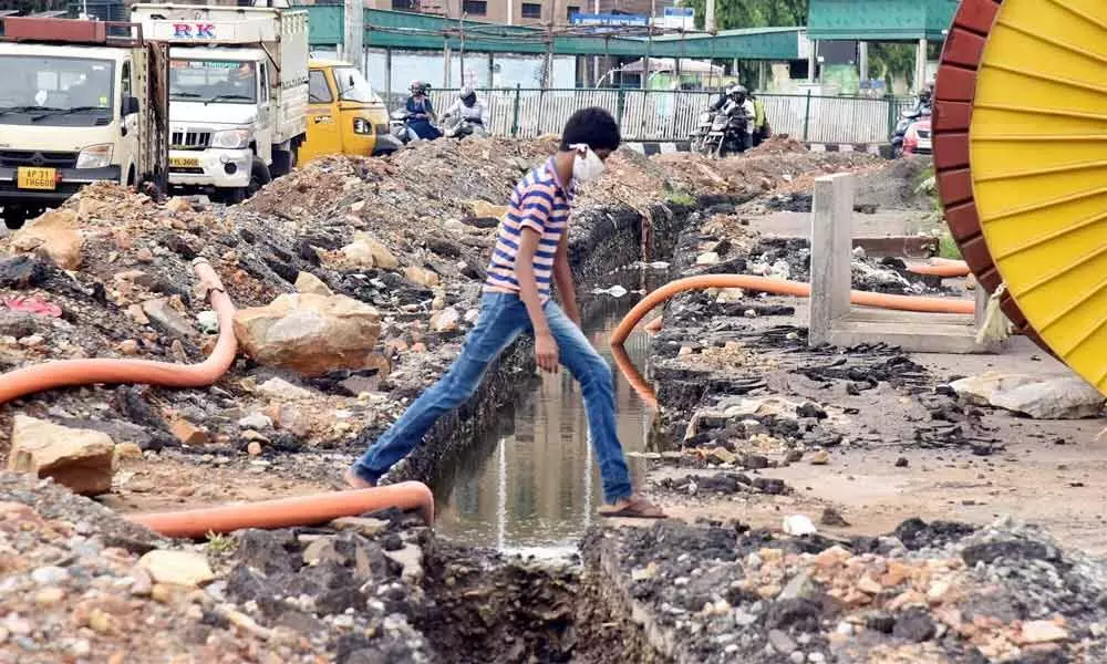 A boy crossing one of the dug-up lanes at Convent junction in Visakhapatnam