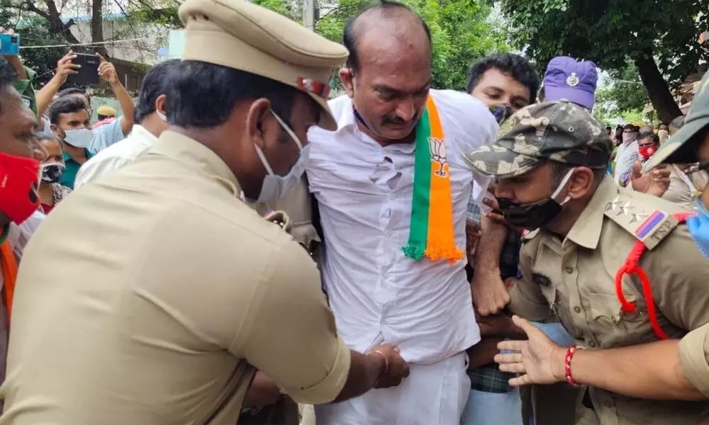 Police arresting BJP Kisan Morcha State president K Sridhar Reddy, who was staging protest, near Rythu Bazaar centre in Khammam town on Friday