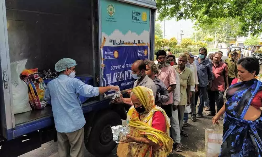 Akshaya Patra Foundation volunteers distribute food packets to the needy to mark the World Food Day celebrations in Visakhapatnam on Friday