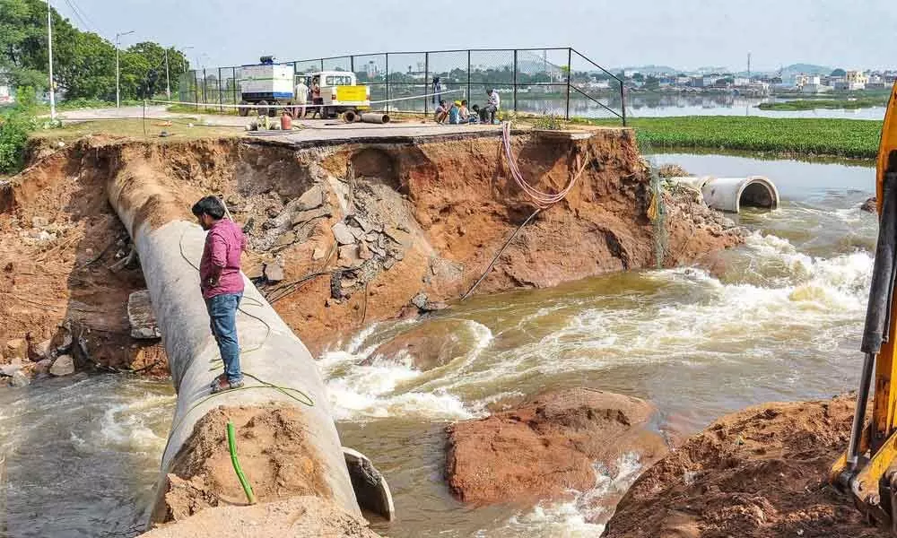 A man looks on at the damaged portion of the retaining walls of Balapur lake, which collapsed last night follwing heavy rainfall in Hyderabad