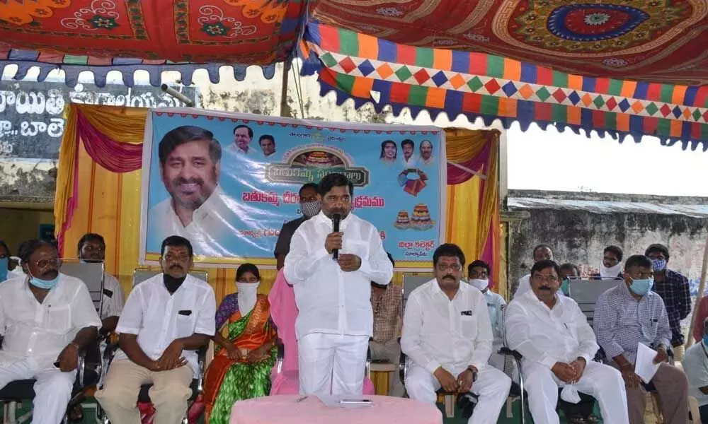Power Minister G Jagadish Reddy addressing the gathering after distributing Bathukamma sarees in Suryapet constituency on Monday