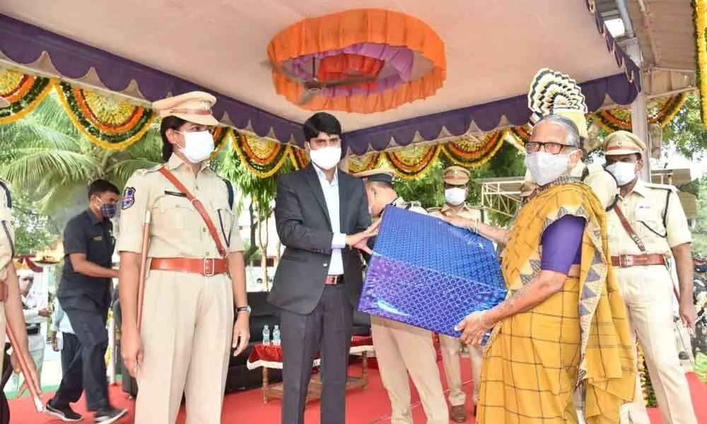 District Collector C Narayana Reddy presenting a gift to the wife of a police martyr at Police Martyrs Remembrance Day programme
