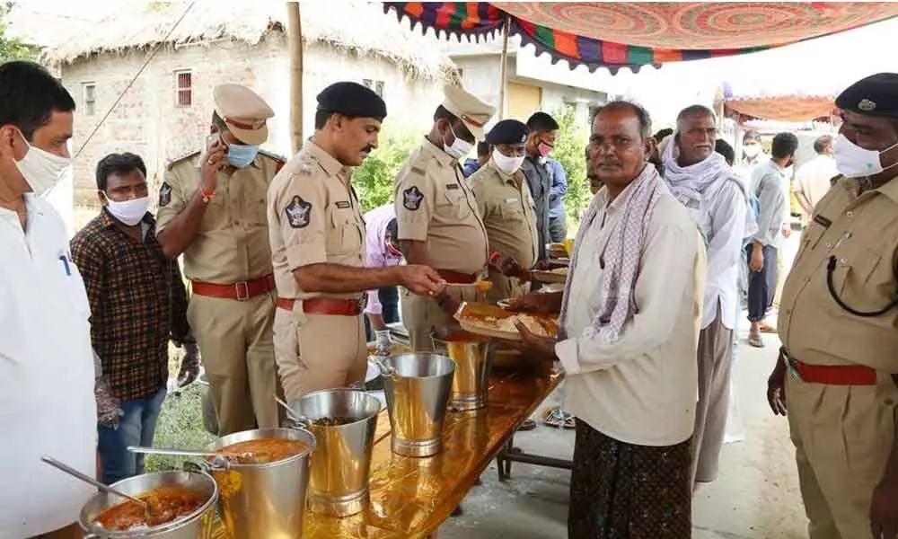 Urban SP RN Ammi Reddy serving food to the poor at Katrapadu village in Guntur district on Tuesday