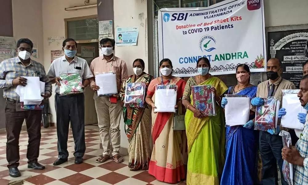 Officials displaying blankets donated by the SBI