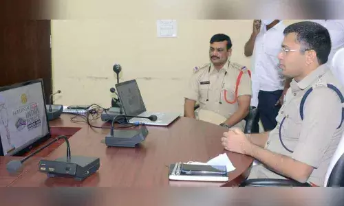 SP Amith Bardhar and Kasibugga CI G Srinivasa Rao watching awards presentation through online from Srikakulam