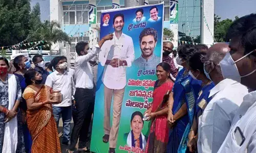 YSRCP leaders performing Palabhishekam to Chief Minister YS Jagan Mohan Reddy’s flexi in Rajamahendravaram on Friday