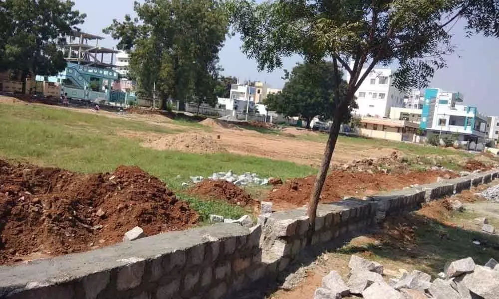 Construction works for a walking track and compound wall going on at Housing Board Colony in Jadcherla