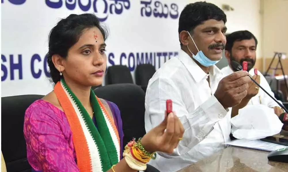 Congress MP D K Suresh and party candidate for Rajarajeshwari Nagar constituency Kusuma release a pen drive containing the videos of BJP workers, allegedly distributing money to voters ahead of by-elections, during a press conference, in Bengaluru, on Sunday