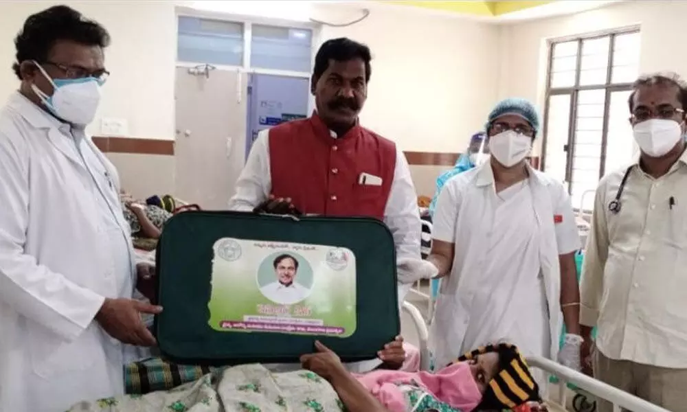 State SC, ST Commission Member Ch Narasimha presenting a KCR Kit to a woman at Khammam Government Hospital