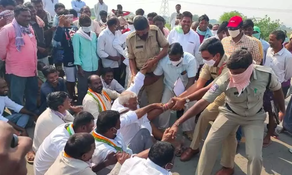 Police evicting Congress leaders, who were staging dharna on the road, to clear the traffic at Narasingapuram village on Tuesday