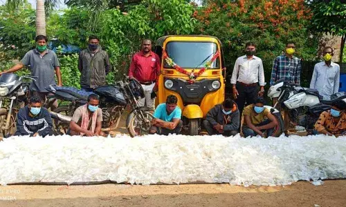 Excise officials with the seized sachets of arrack at Parvathipuram of Vizianagaram district