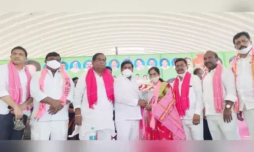 Energy Minister Jagadish Reddy congratulating Nakrekal Agriculture Market Committee chairman Nadikudi Uma Rani during oath taking programme in Nakrekal
