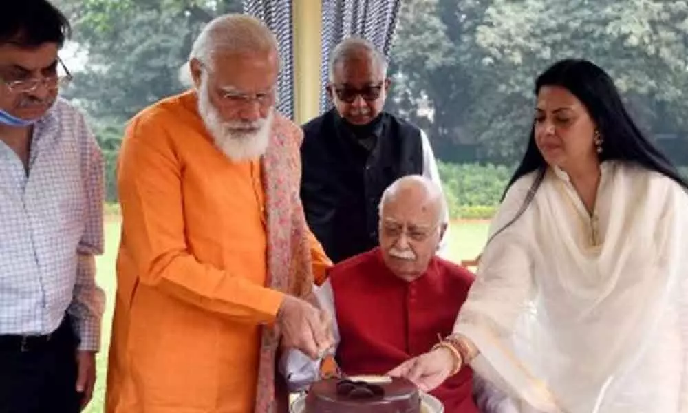The Prime Minister went to Advanis residence here to extend his greetings and was seen helping Advani cut the birthday cake.
