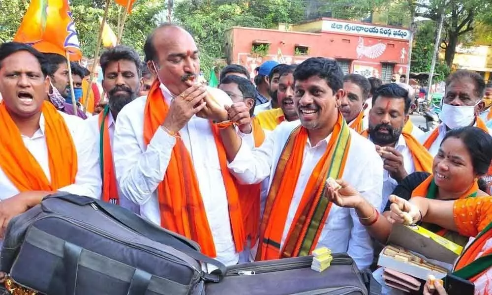 BJP leaders distributing sweets over the victory of party candidate in Dubbaka  by-poll, in Khammam on Tuesday
