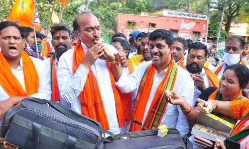BJP leaders distributing sweets over the victory of party candidate in Dubbaka  by-poll, in Khammam on Tuesday
