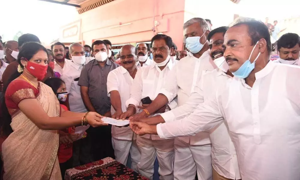 Ministers Peddireddy Ramachandra Reddy, K Narayana Swamy, local public representatives hand over a chque for Rs 50 lakh to the wife of martyred soldier C Prasanna Kumar Reddy at Reddivaripalle village in Chittoor district on Sunday