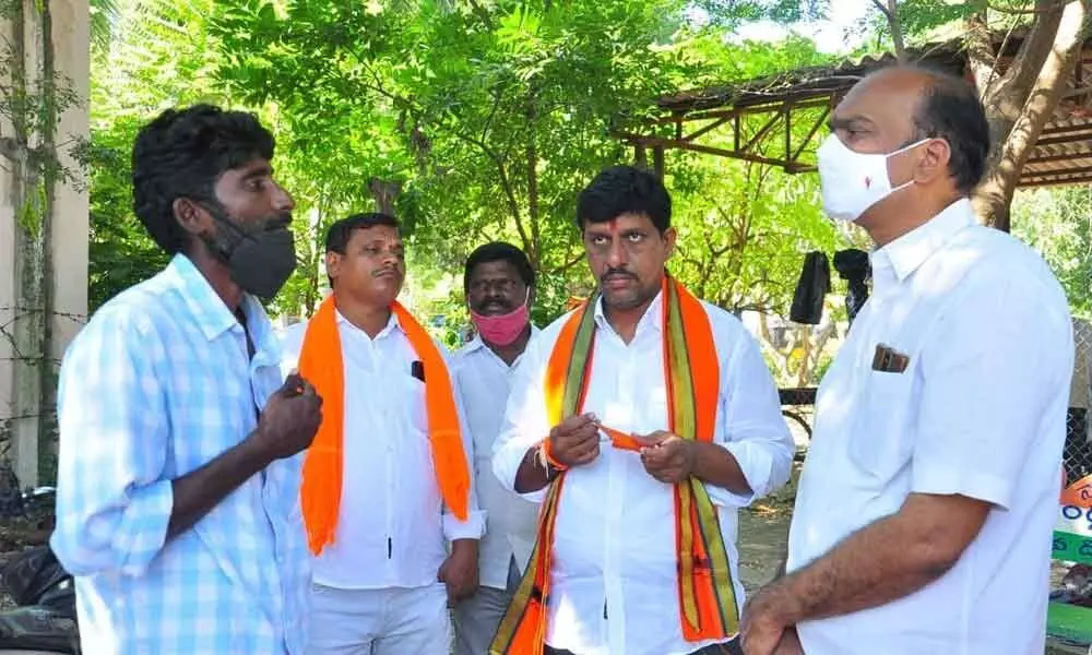 BJP leaders K Sridhar Reddy and Galla Satyanarayana interacting with the woman farmer’s husband at Khammam
