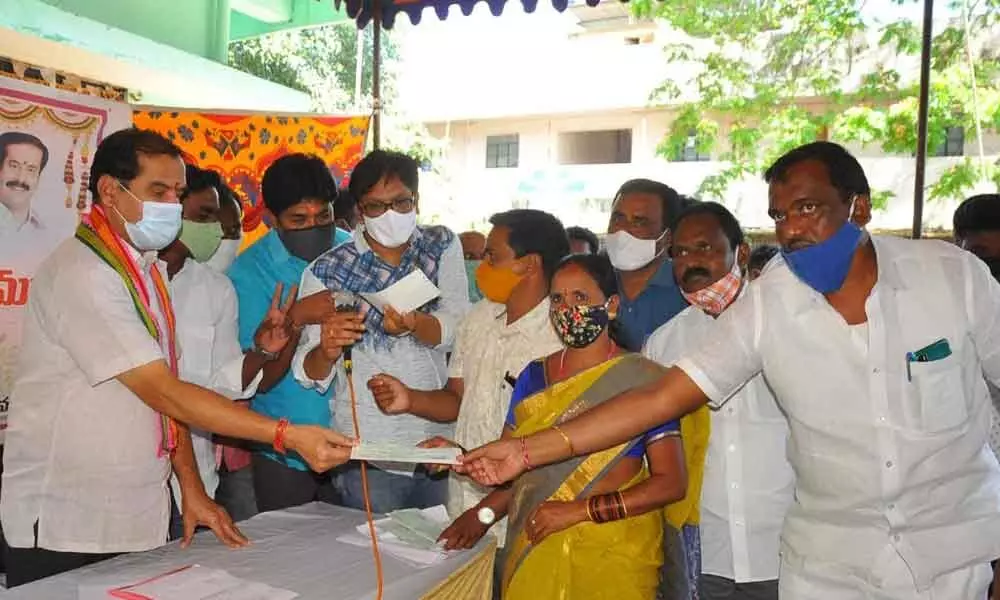 Government Chief Whip D Vinay Bhaskar giving away cheque to a Kalyana Laxmi beneficiary in Kazipet on Tuesday
