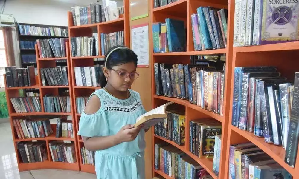 Nine-year-old Mihika Chintala enjoys being surrounded with books 	Photo: A Pydiraju