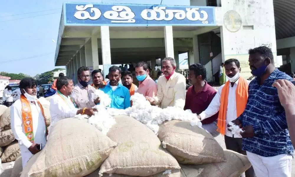 Farmers with their cotton at Enumamula Agriculture Market Yard in Warangal on Friday