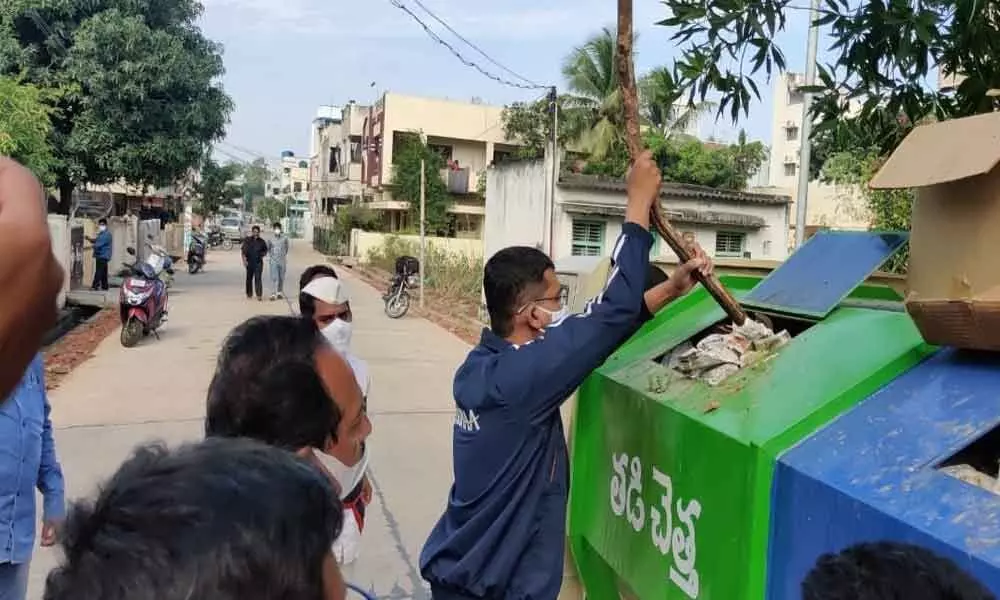 Smart City CEO and MD, Municipal Commissioner Swapnil DinakarPundkar pressing garbage with a stick in Kakinada