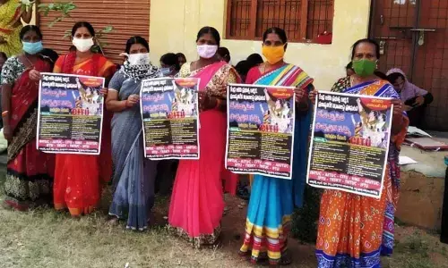 Anganwadi teachers and Aayas staging a protest in front of the ICDS office at Madnoor mandal headquarters on Monday
