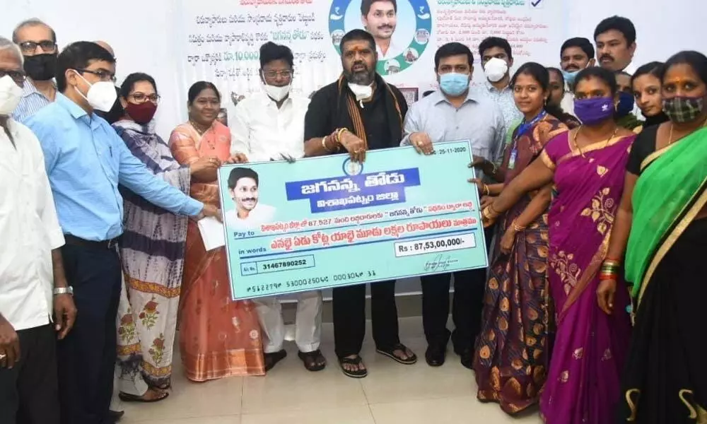 Tourism Minister Muttamsetti Srinivasa Rao handing over a cheque of Rs 87.53 crore to the beneficiaries of Jagananna Thodu scheme in Visakhapatnam on Wednesday