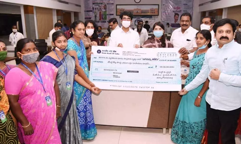 District Collector D Muralidhar Reddy distributing cheque for Rs 90.97 crore to the beneficiaries in Kakinada on Wednesday