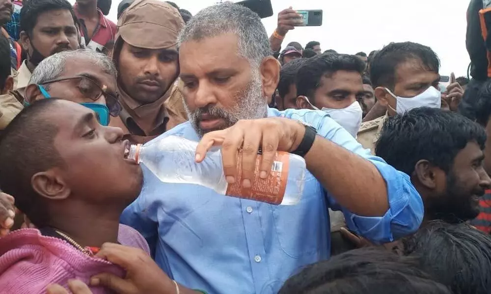 MLA Chevireddy providing water to a victim, who was rescued by him and fire personnel, at Ralla Madugu on Thrusday