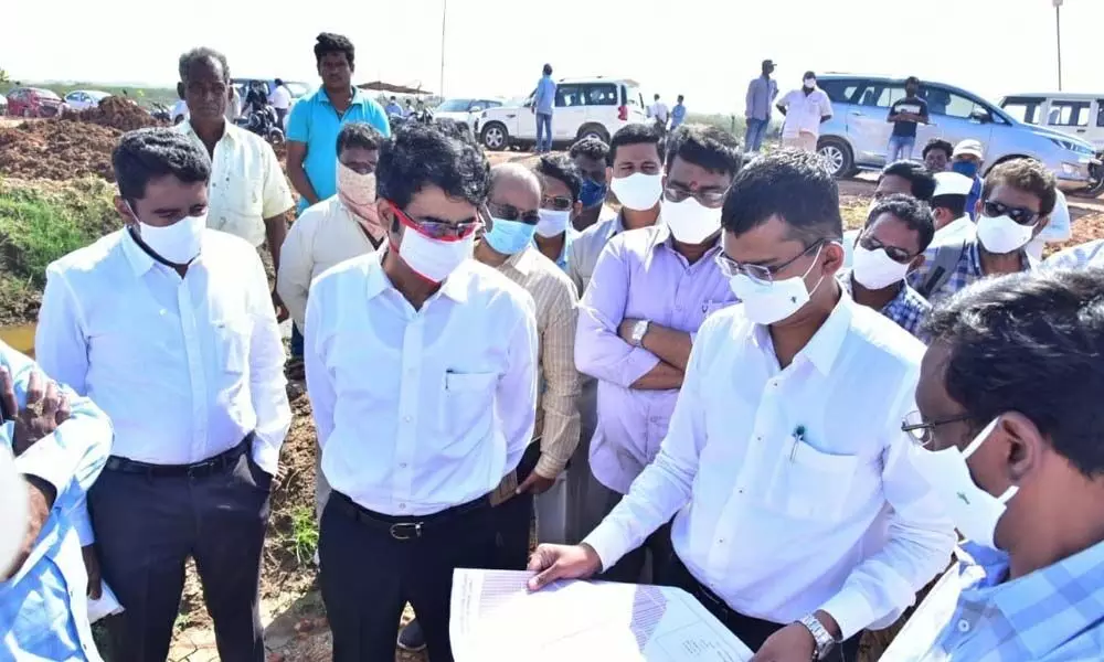 District Collector D Muralidhar Reddy inspecting layout works along with Kakinada Municipal Commissioner Swapnil Dinakar Pundkar at Komaragiri village on Monday