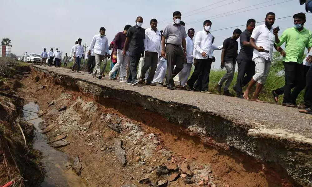 District Collector K V N Chakradhar Babu inspecting a damaged road in Bogole mandal on Tuesday. Kavali MLA MLA R Prathap Kumar Reddy is also seen.