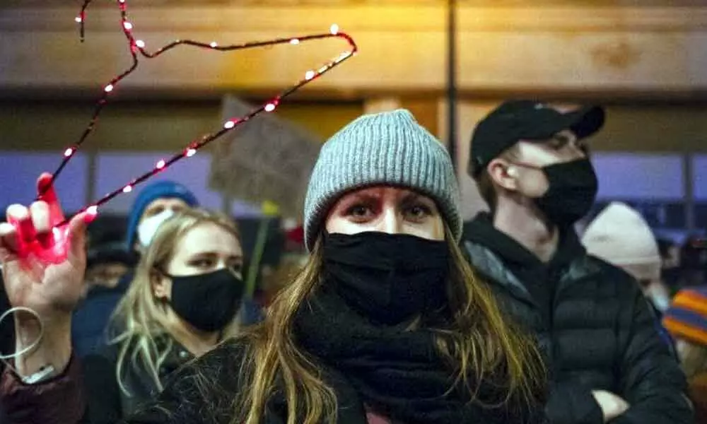 A demonstrator holds a coat-hanger, a symbol of the self-induced abortion, during a protest against a top court ruling restricting abortions in Warsaw, Poland.