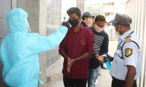 Staff conducting thermal scan before allowing people into a cinema hall in Srikakulam city on Friday