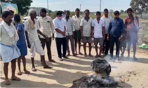 Farmers burning paddy bags  at a PACS centre in Nasrullabad village on Friday