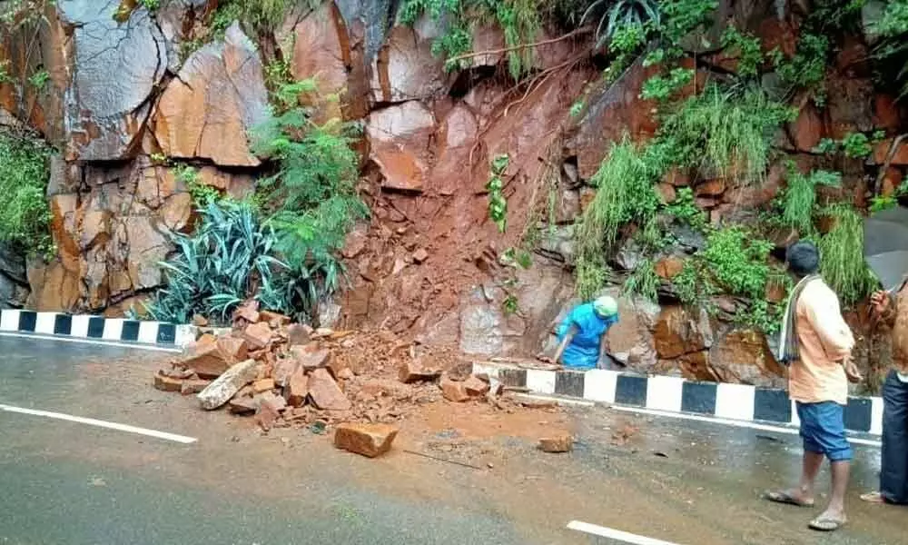 Officials removing boulders with earthmover on ghat road in Tirumala