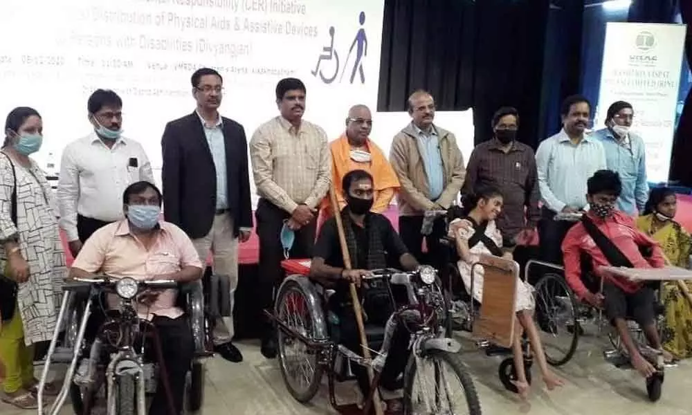 Director (Personnel), RINL, Kishore Chandra Das, with beneficiaries at the free distribution of physical aids to the differently-abled persons in Visakhapatnam on Tuesday
