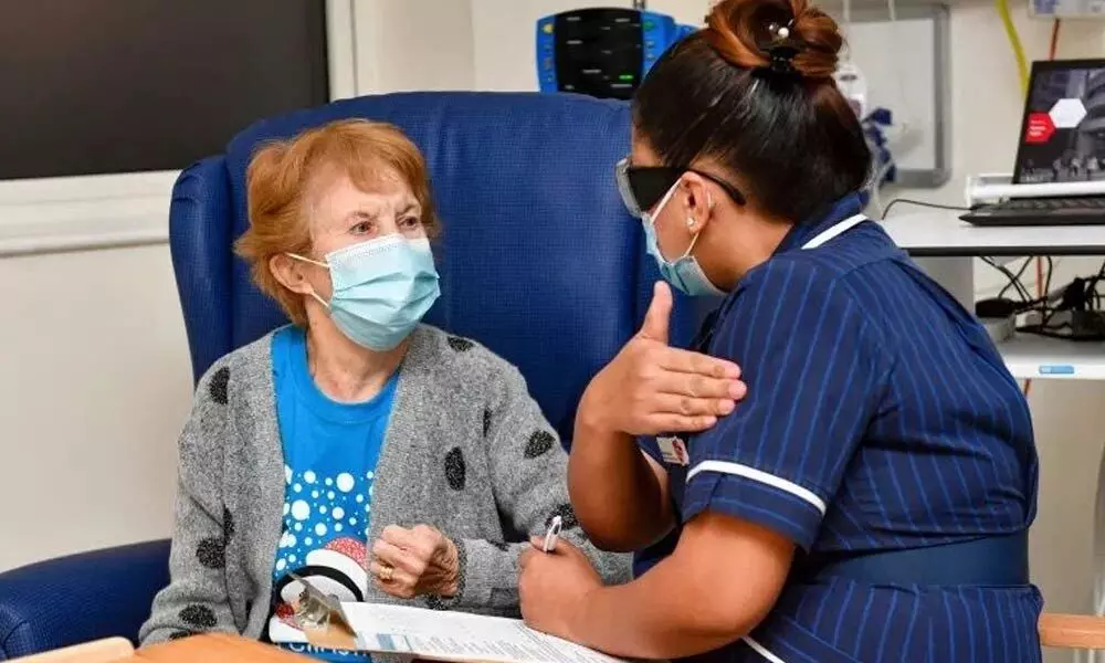 Nurse May Parsons prepares 90-year-old Margaret Keenan, the first patient in the UK to receive the Pfizer-BioNTech Covid-19 vaccine, at University Hospital, Coventry, England on Monday