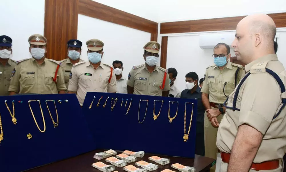 East Godavari District SP Adnan Nayeem Asmi examining the gold ornaments and cash seized from the accused in Kakinada on Saturday